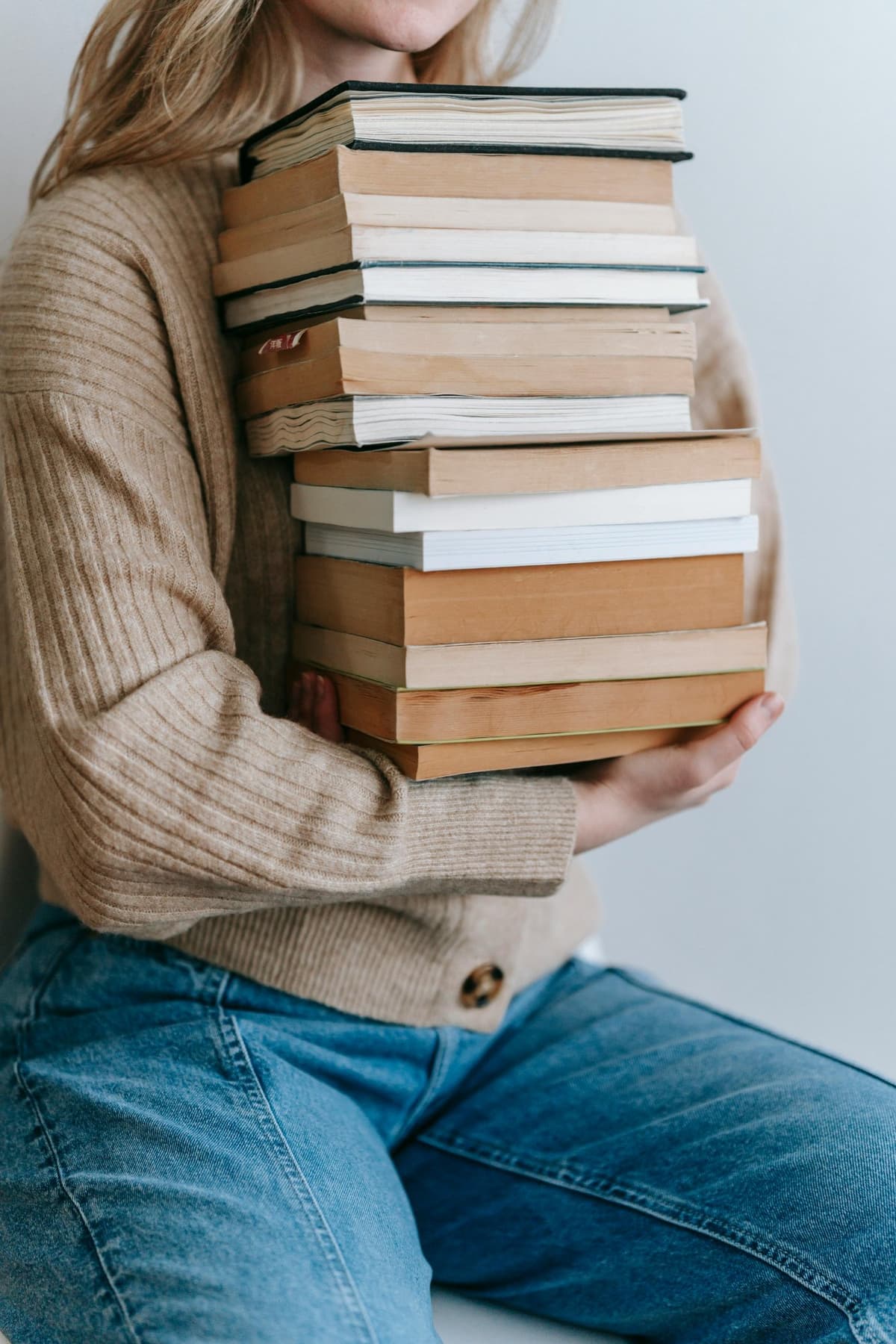 Woman holding stack of books